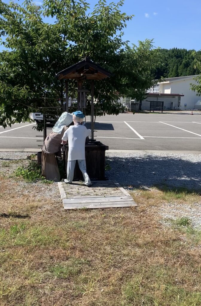 駐車場を見ているかかしの写真